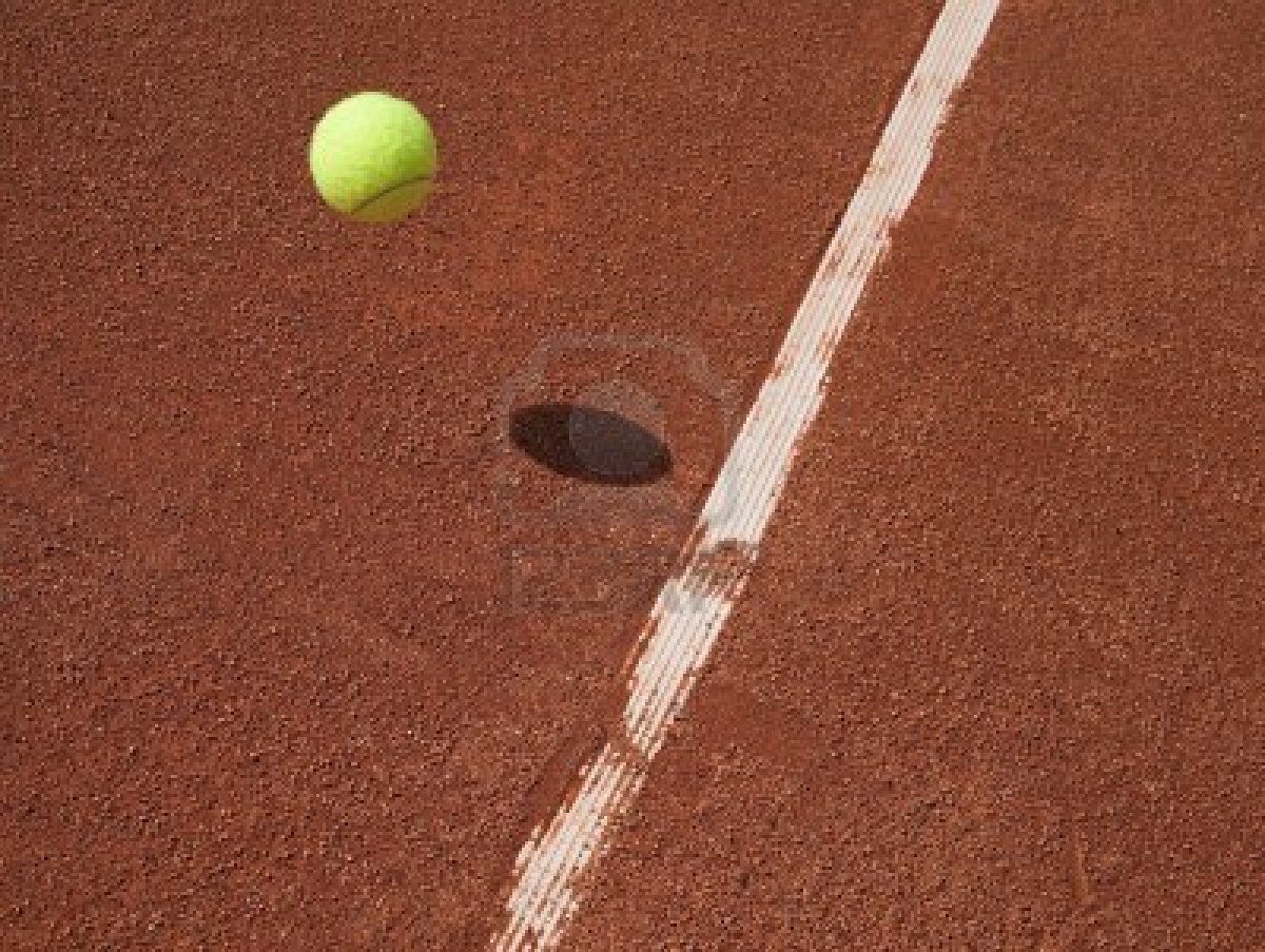 9796783-tennis-bal-in-de-lucht-het-naderen-van-de-lijn-op-een-rode-gravel